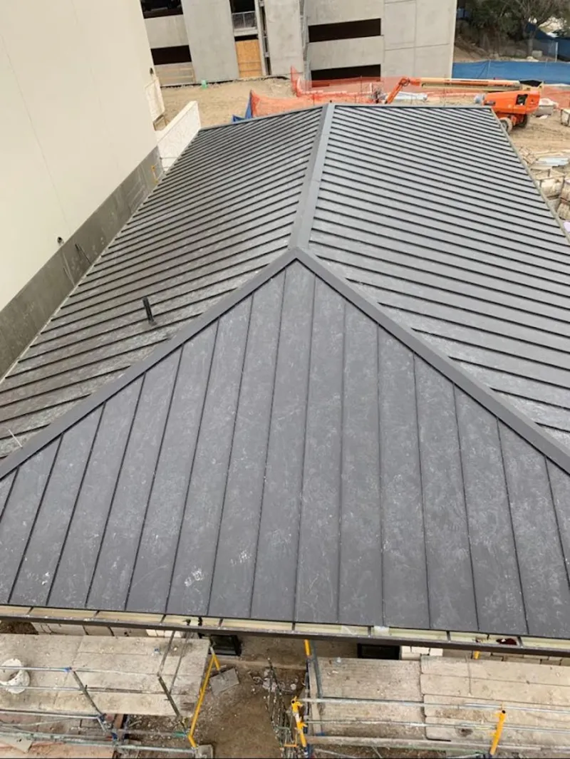 Commercial metal roof construction with crane equipment in Centreville